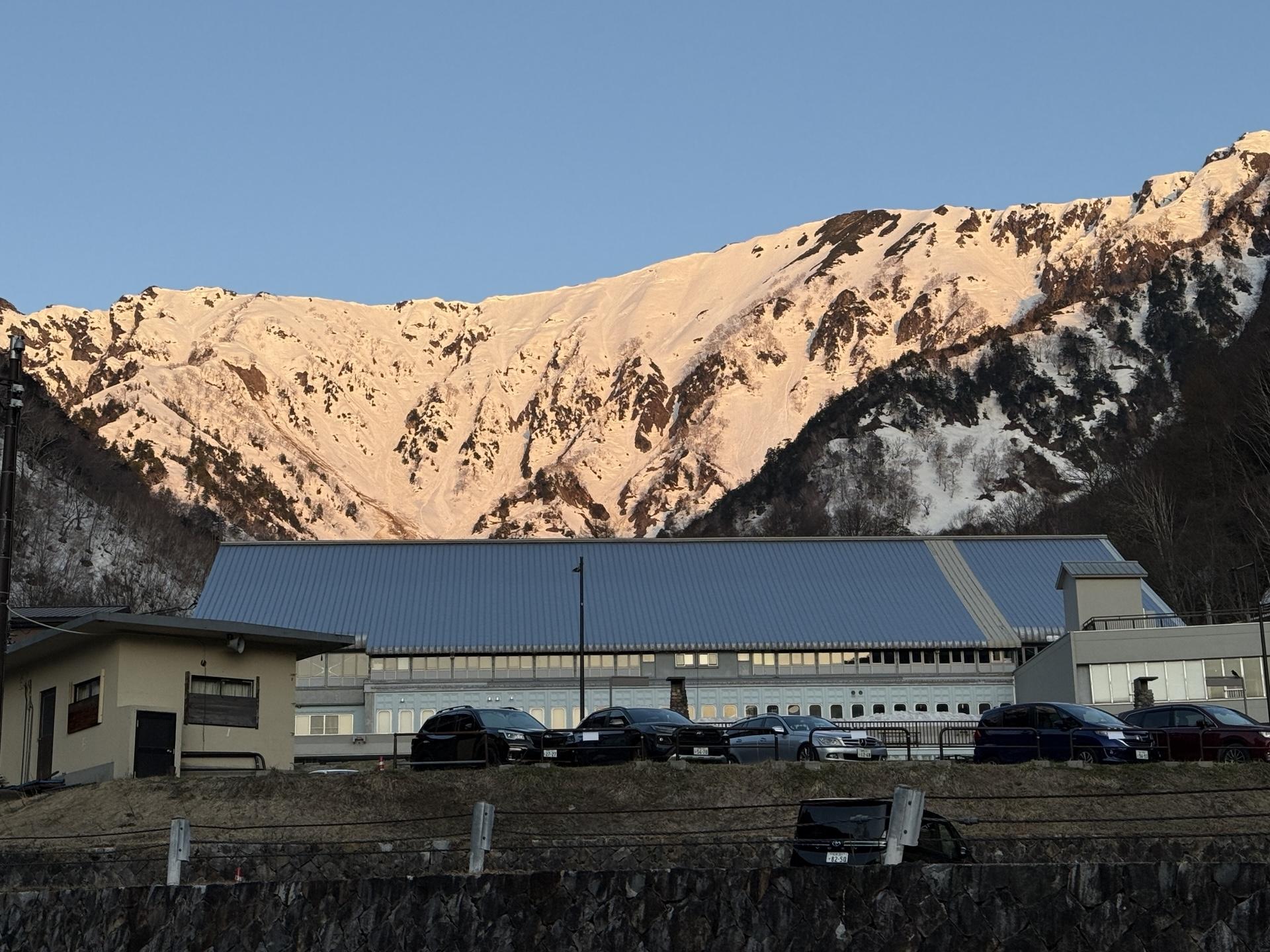 扇沢駅の奥の山々が朝陽に照らされてモルゲンロート