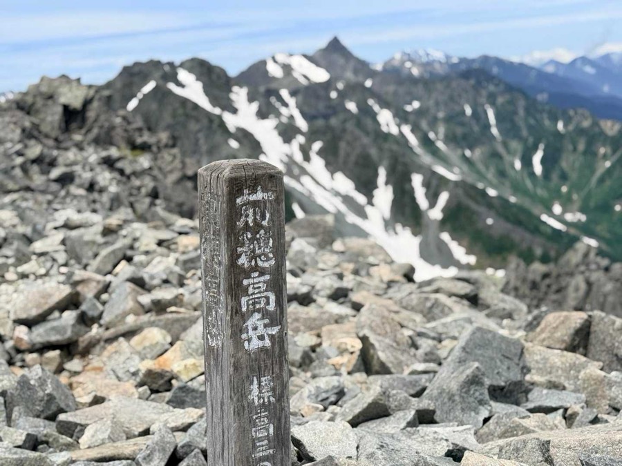 前穂高岳(3,090m)の標識と槍ヶ岳(3,180m)。前穂は国内標高第11位