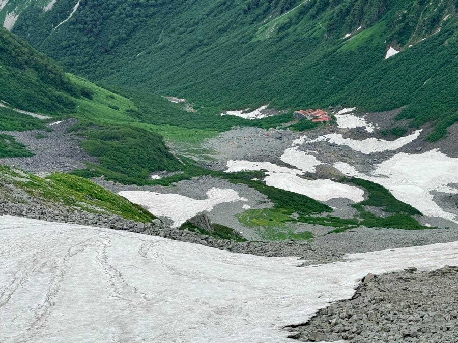 テラスから見下ろす雪渓と涸沢ヒュッテ